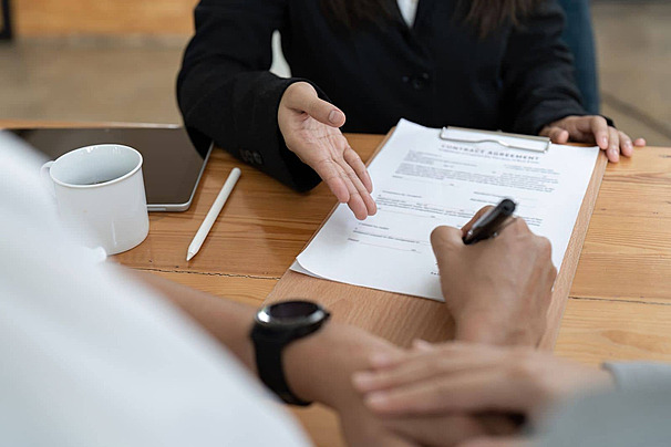 pngtree-real-estate-agent-witnessing-a-young-couple-signing-a-contractual-agreement-photo-image_49309658